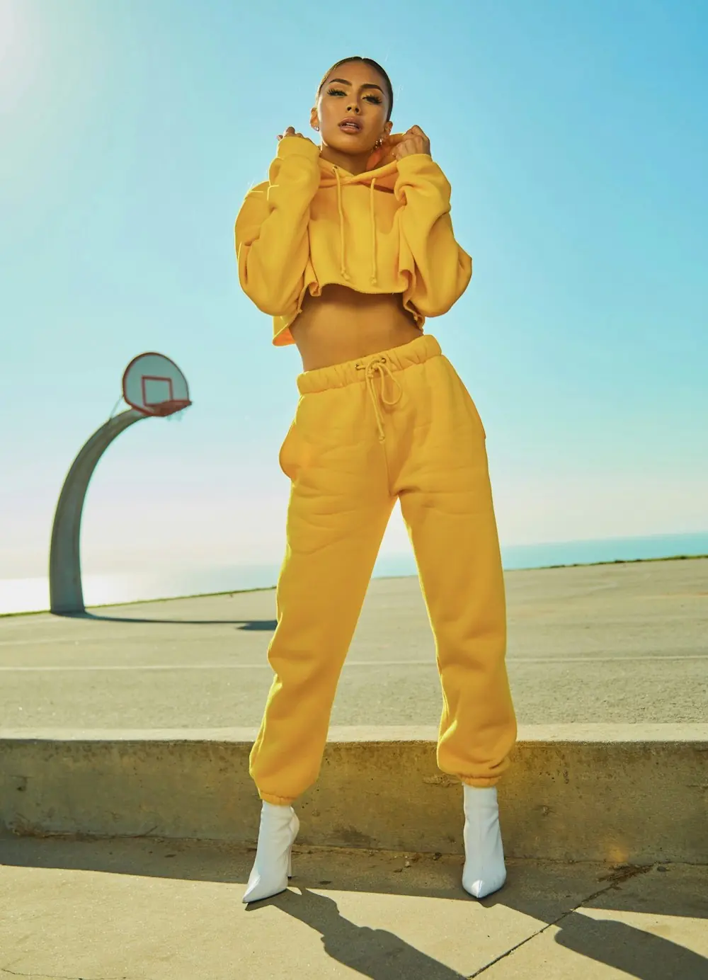 A woman in a yellow tracksuit on a basketball court